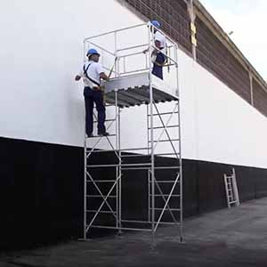 Dois trabalhadores em cima de uma torre de 2 metros de andaimes tubulares.